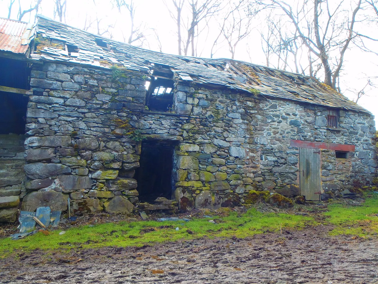 The old stone barn before renovation, with a broken slate roof