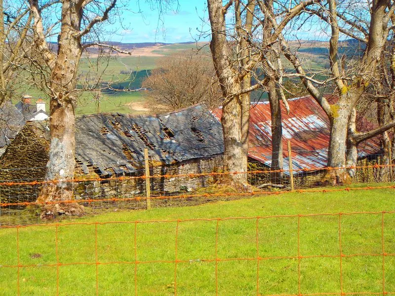 Looking down over the old roofs, with the farmhouse chimneys and the hills behind.