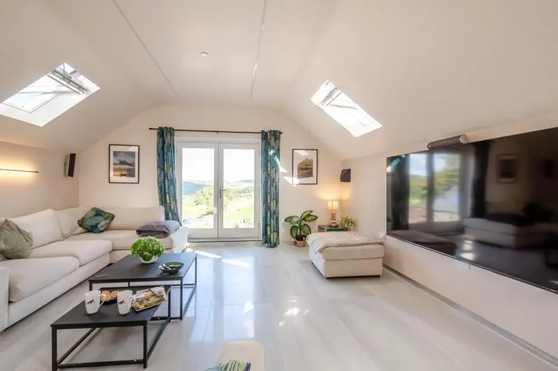 Lounge with L-shaped sofas and large Smart TV